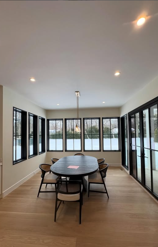 Dining room with wall of black-framed windows