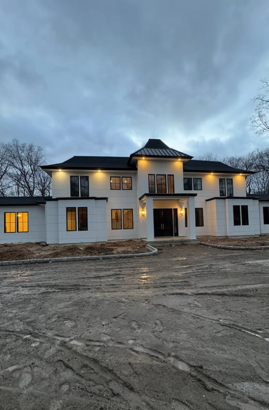 Custom home exterior at dusk with soffit lighting