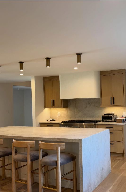 Kitchen with cylinder ceiling spots over a waterfall island